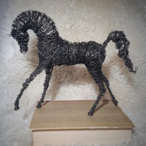 Tumma rautalangasta tehty laukkaava hevonen